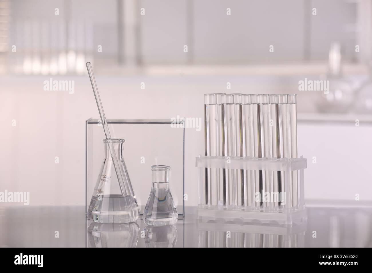 Laboratory analysis. Different glassware with liquid on white table ...