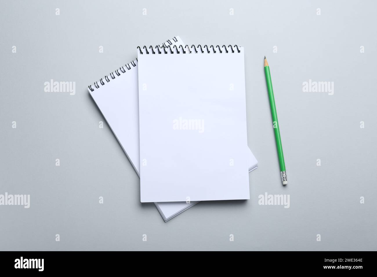 Notebooks and pencil on light grey background, top view Stock Photo