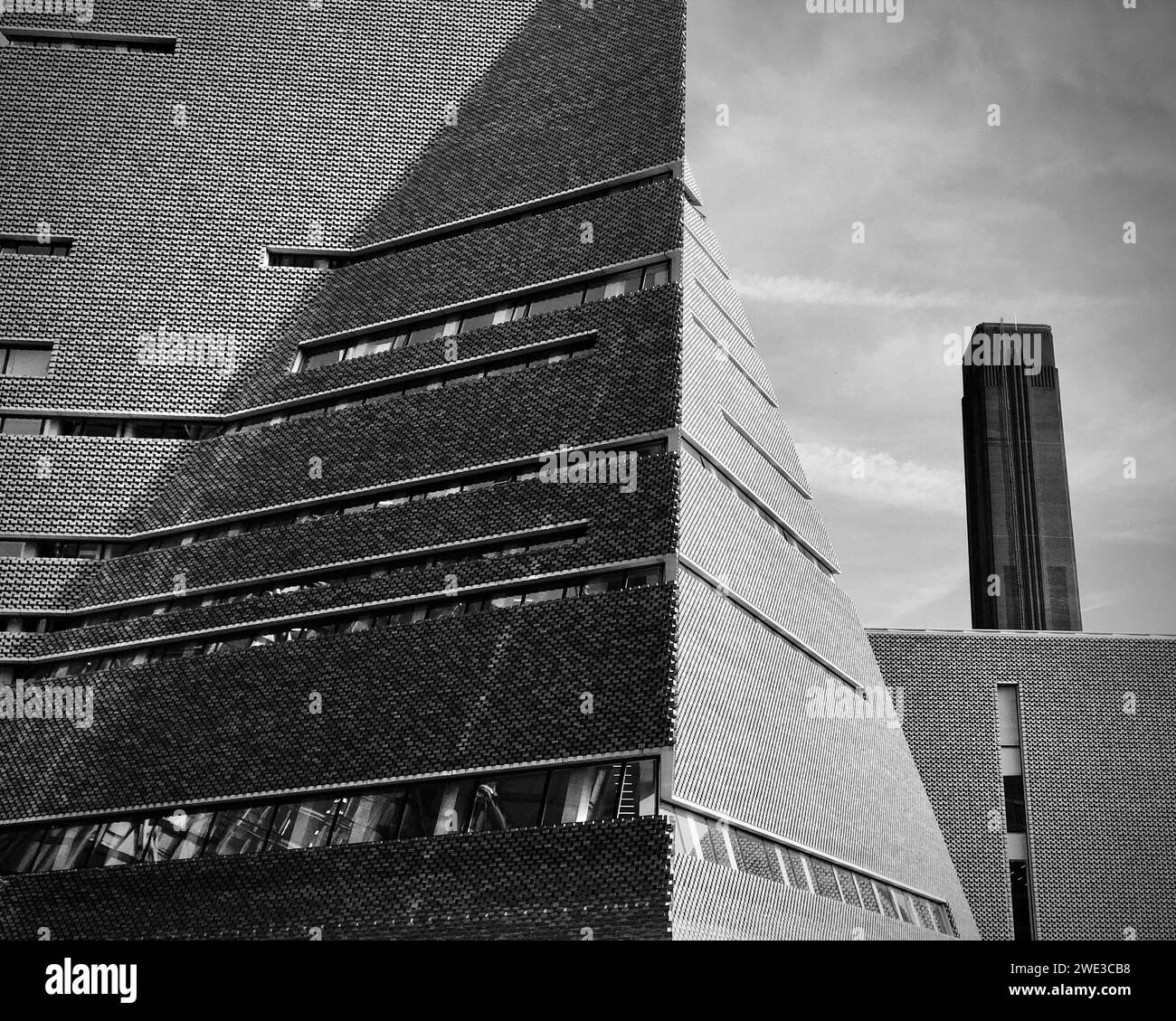 The new and old architecture of the Tate Modern with the large old chimney stack of the Turbine Hall including the new building extension. Stock Photo