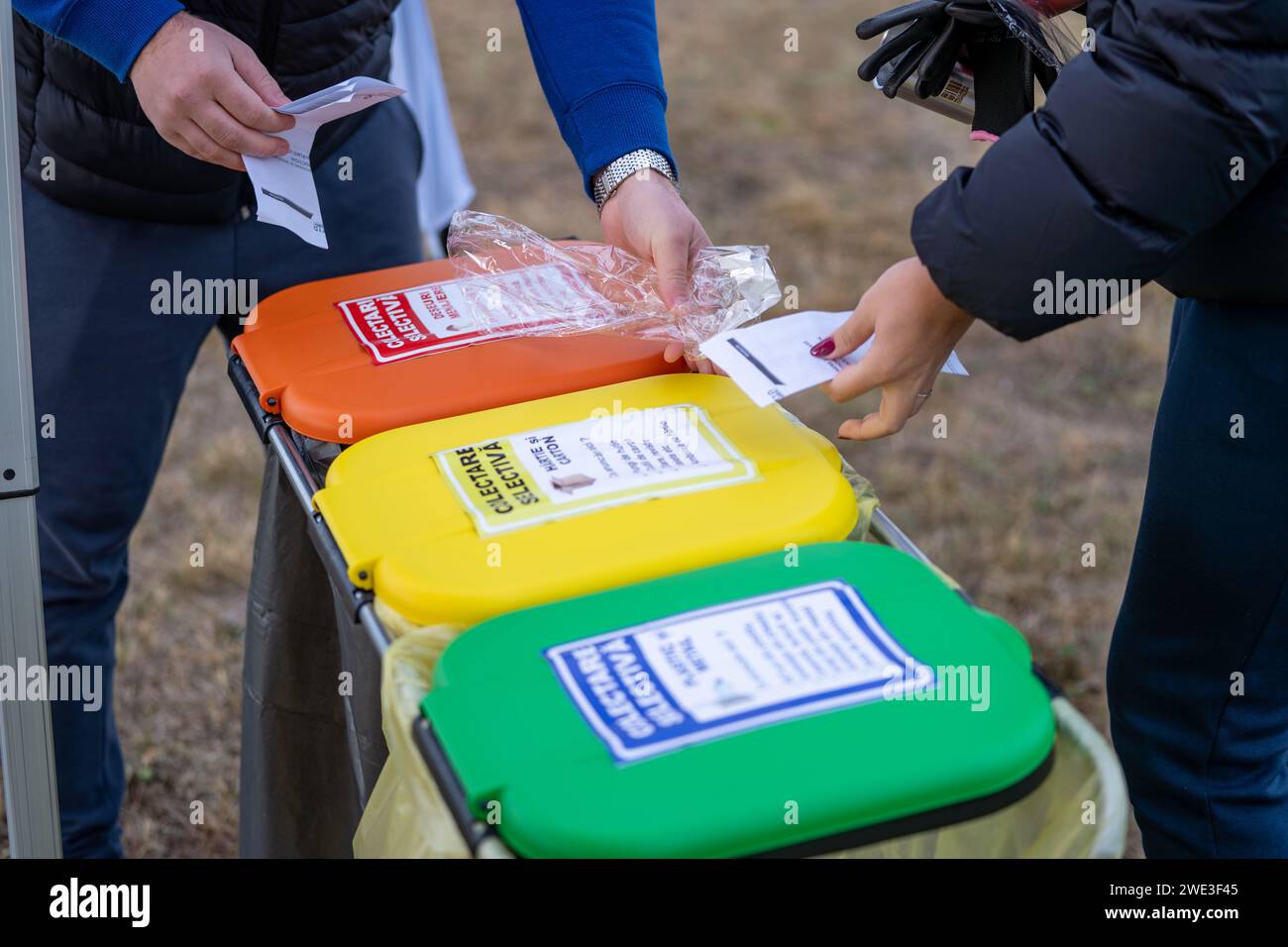 A group of people throwing garbage in the recycling garbage trash Stock