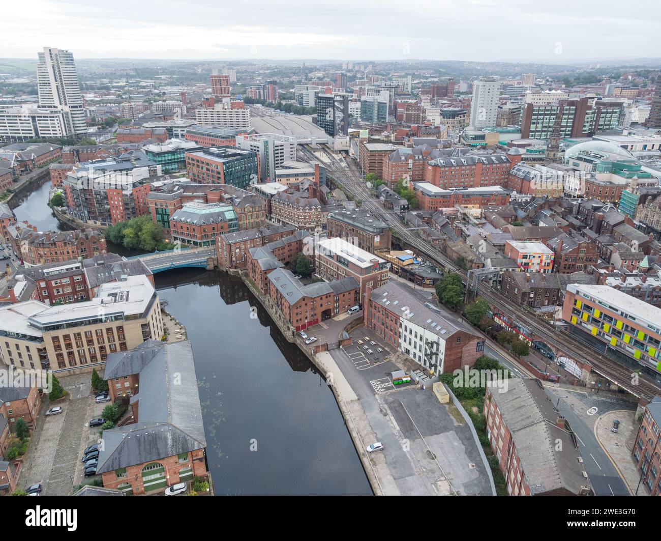 Aerial image over the winding River Aire in Leeds, Yorkshire, UK with Leeds Bridge, Leeds city train station and tracks with the wider city centre Stock Photo