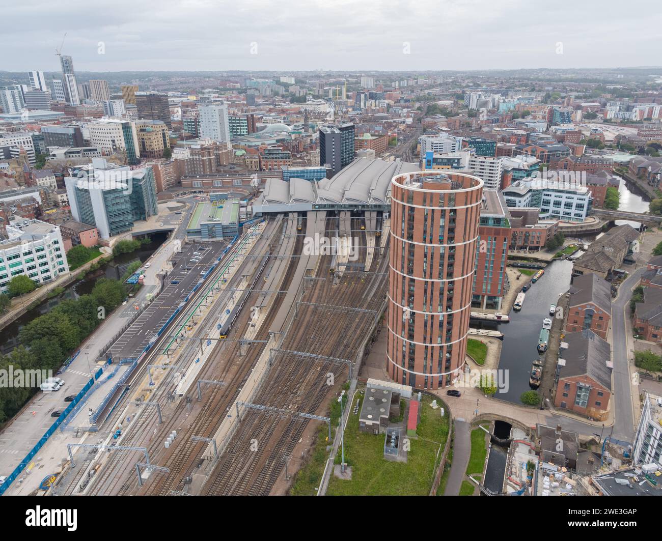 Aerial photograph of Leeds train station with platforms, roof, trains, tracks, Candle House and the wider Leeds city centre, Yorkshire, UK Stock Photo