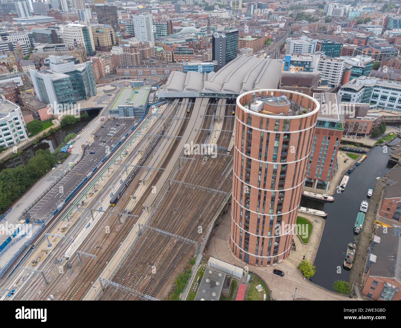 Aerial photograph of Leeds train station with platforms, roof, trains, tracks, Candle House and the wider Leeds city centre, Yorkshire, UK Stock Photo