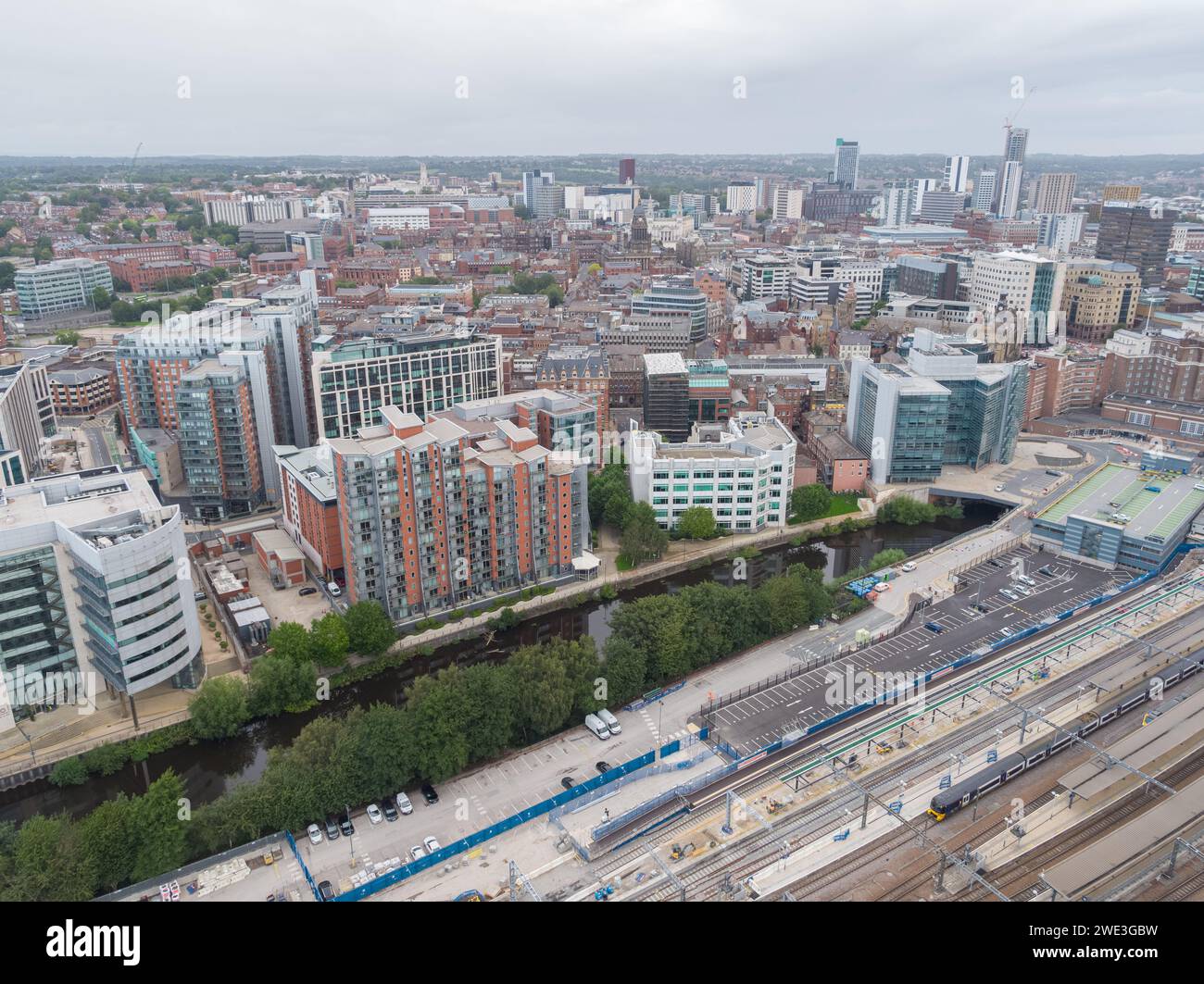 Aerial photograph of a train leaving Leeds Station and car park, Princes Exchange, Whitehall Quay, River Aire and the wider city centre, Yorkshire, UK Stock Photo