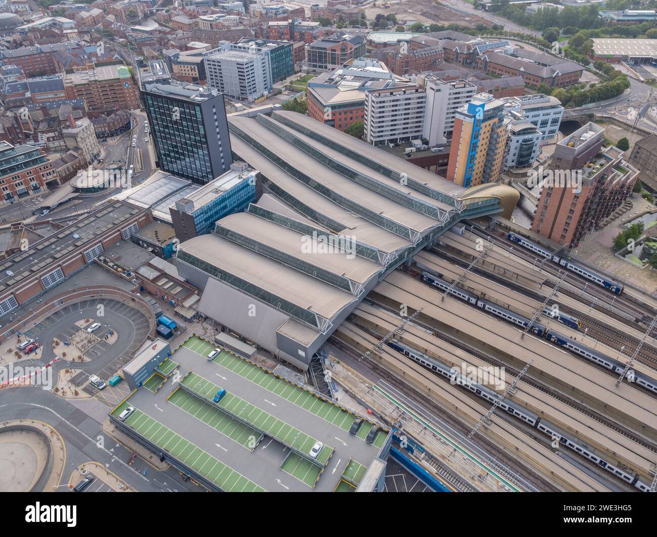 Aerial image of the roof, platforms, tracks, lines & trains at Leeds Station, with City House in Leeds city centre, Yorkshire, UK Stock Photo