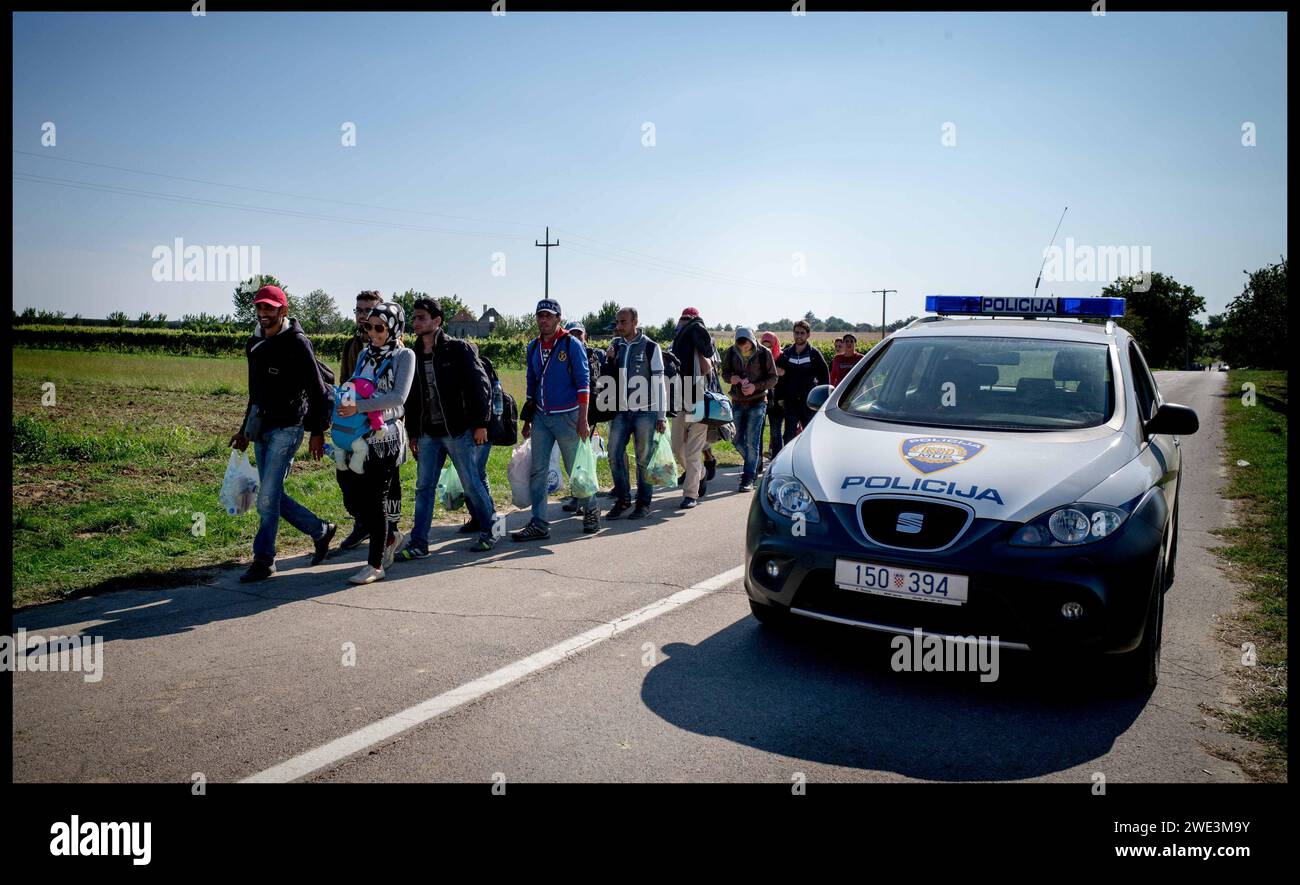 Image ©Licensed to Parsons Media. 22/09/2015.Croatia. Migrants in Croatia. Migrant children.    A Croatian police car sits on the border of Croatia and Serbia as migrants walk across the border into Croatia,  as they make their way to Hungary.   Picture by Andrew Parsons / Parsons Media Stock Photo
