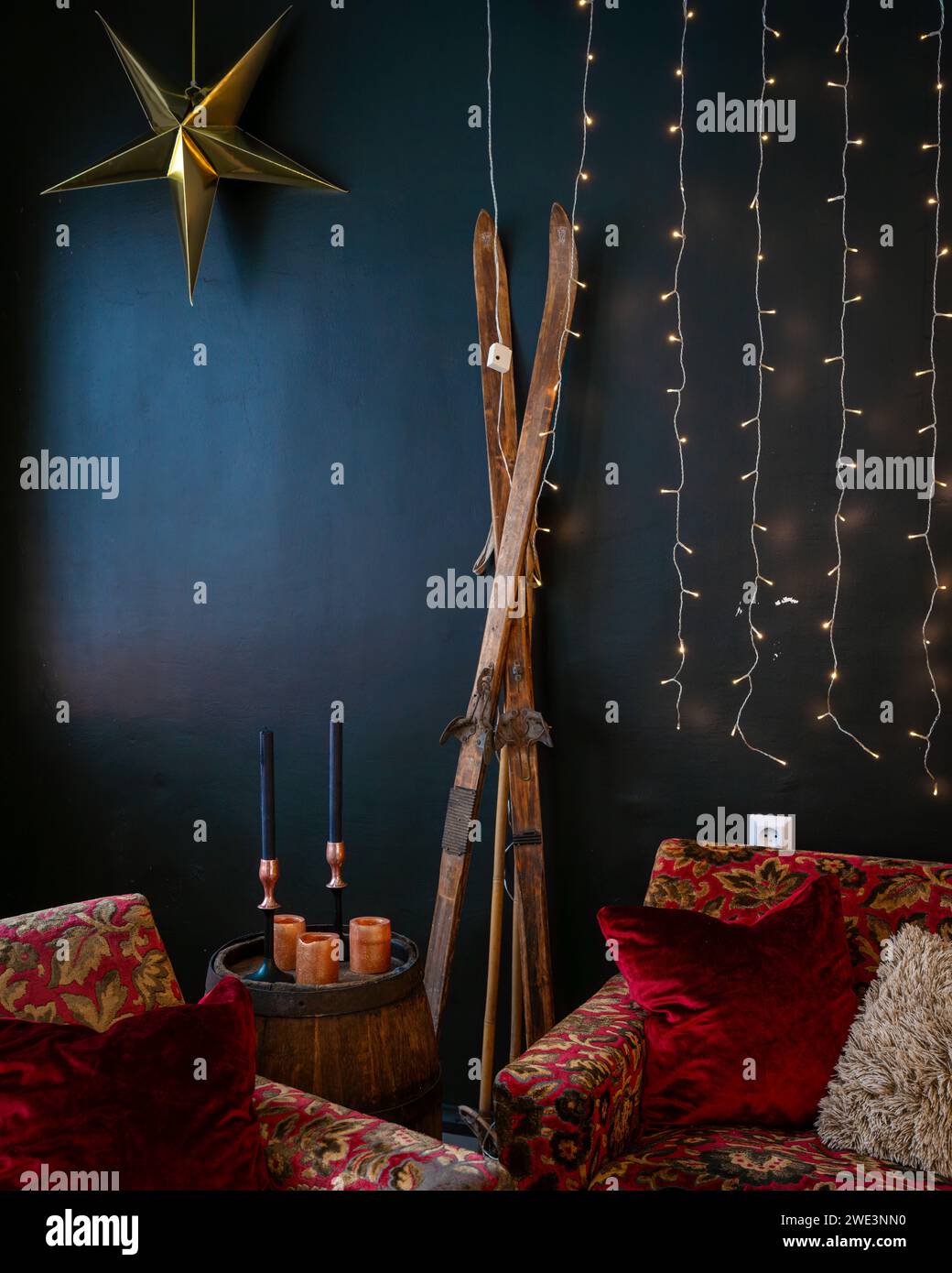 Interior with wooden barrel, old skis, candle with candle stick, decoration. Interior design of christmas. Stock Photo