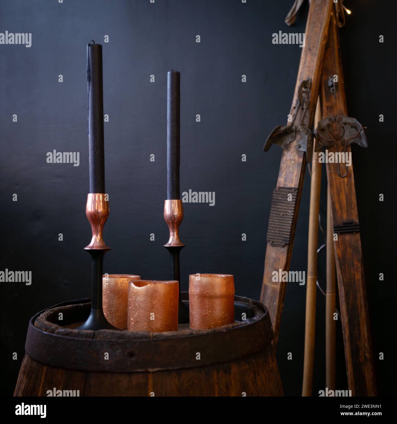 Interior with wooden barrel, old skis, candle with candle stick, decoration. Interior design of christmas. Stock Photo