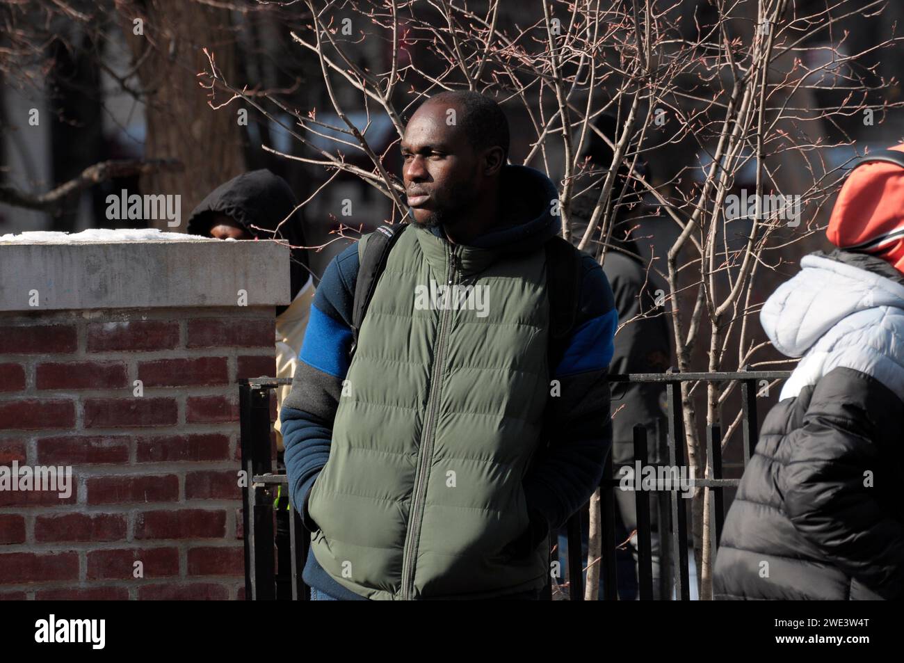 New York, United States. 22nd Jan, 2024. A migrant waits outside Tompkins Square Park. Single adult migrants who were authorized by New York City to leave the shelter system after 30 days, wait in line outside of a closed down St. Brigid School in the East Village. The former school serves as a re-intake center for migrants seeking relocation to another shelter. The migrants have been waiting outside in the freezing winter temperature as aid groups have been donating food and clothing. Credit: SOPA Images Limited/Alamy Live News Stock Photo