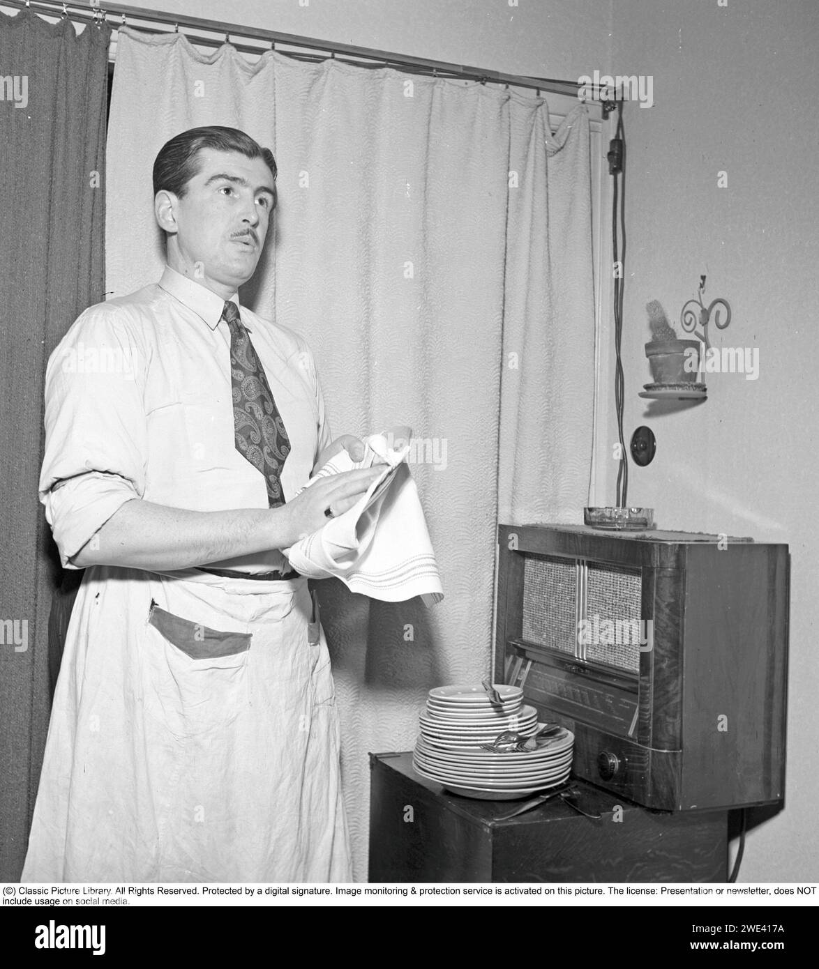 Radio listener in the 1940s. A man listens to the radio broadcast from