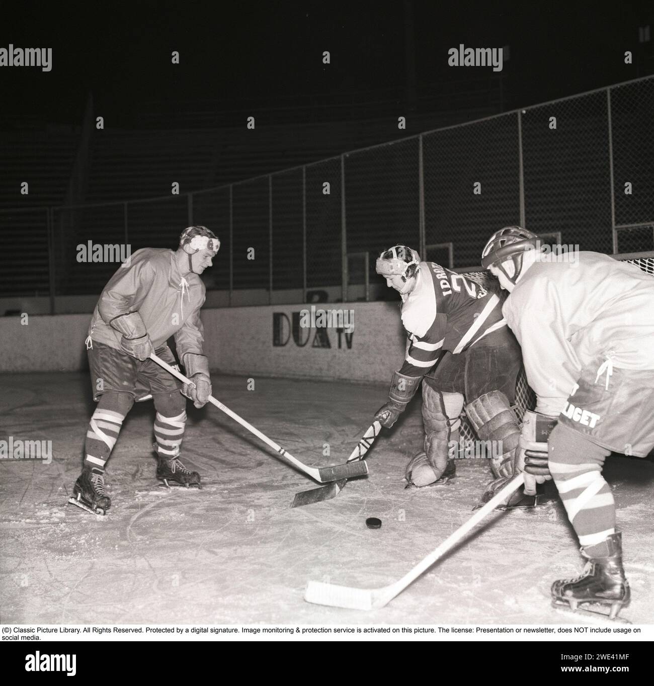 Ice hockey in the 1950s. A goalkeeper and two players on the ice hockey rink. 1959. Kristoffersson ref CL19-11 Stock Photo