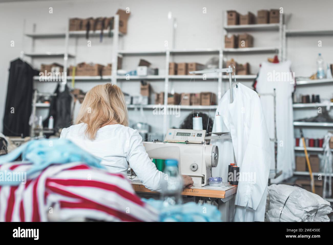 Working Clothes Machine clothing industry worker working on sewing machine Stock Photo - Alamy