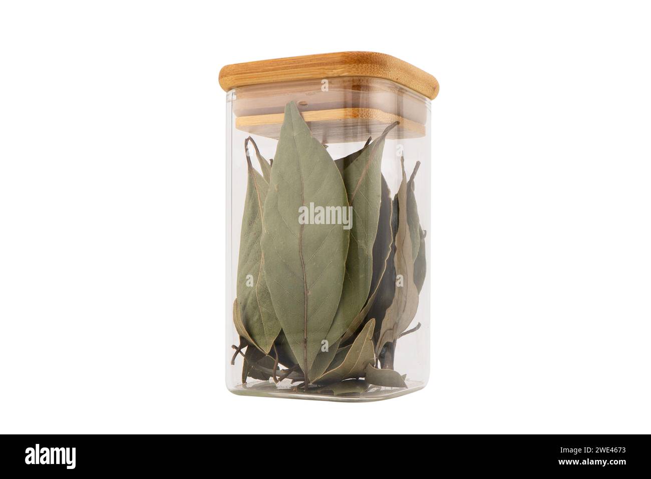 Dry bay leaf in glass jar isolated on a white background. Green bay leaf. Aroma ingredient. Natural healthy food and diet. Stock Photo