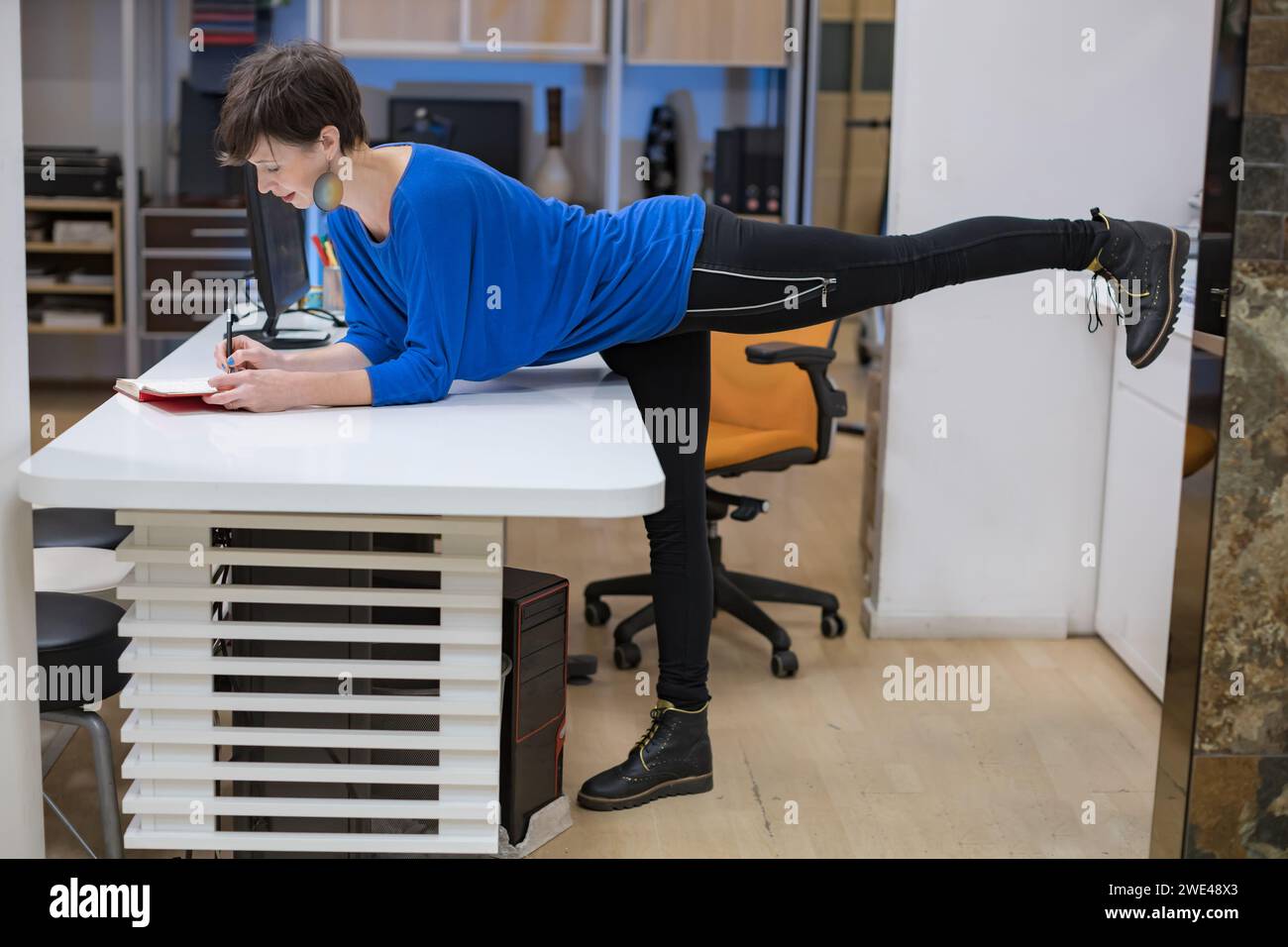 young woman stretching in the office Stock Photo
