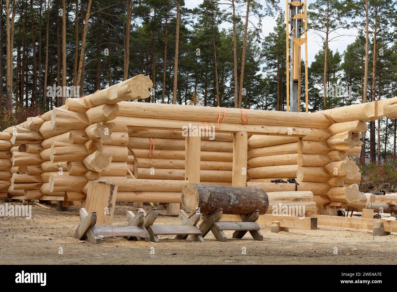 The construction site of a wooden house. Traditional log cabin built from wood logs on sunny