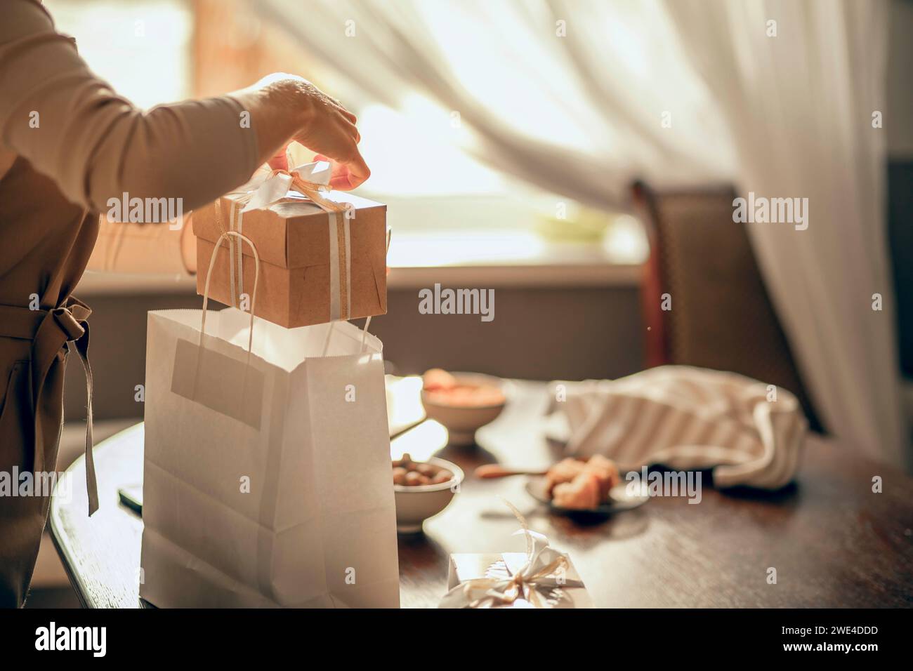 Owner Pack female bakery owner packs boxes for customer's order in birthday ...