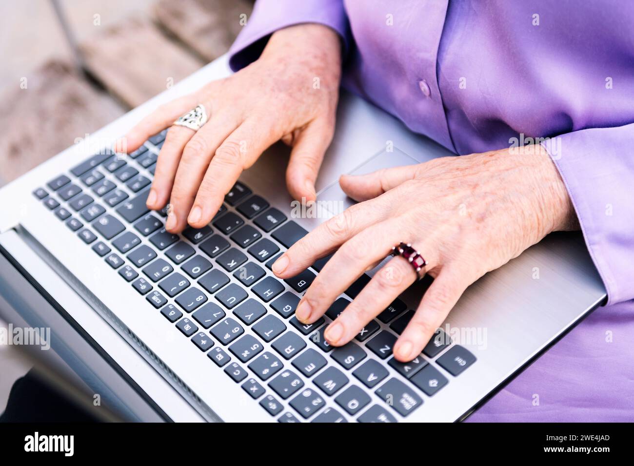 hands of a senior woman typing on a laptop Stock Photo