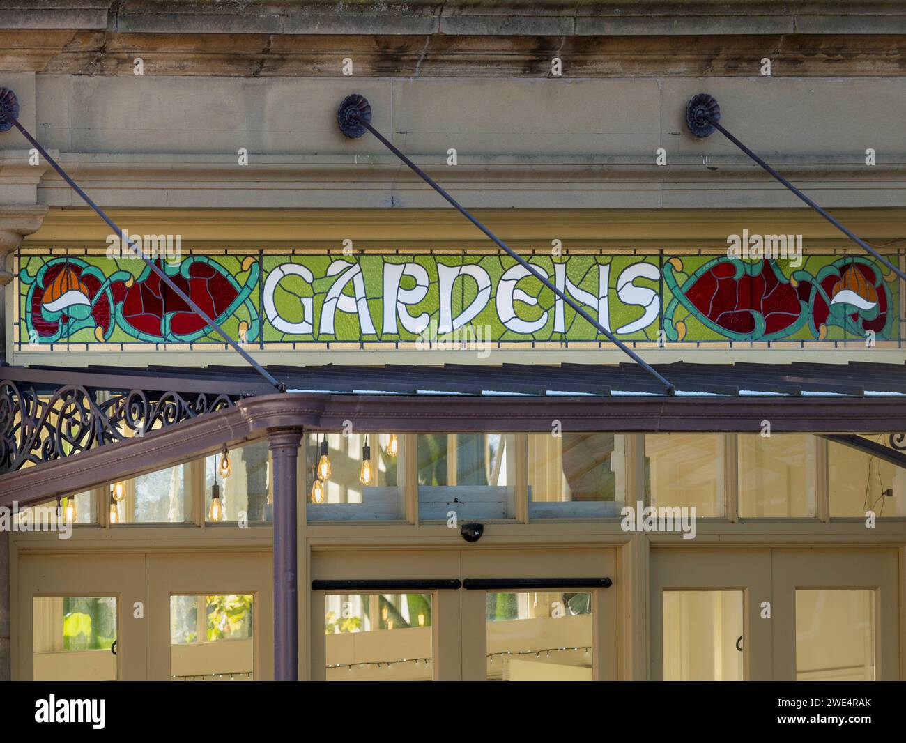 Stained glass panel inset with the word GARDENS above the entrance canopy of The Conservatory in the Pavilion Gardens. Buxton. Stock Photo