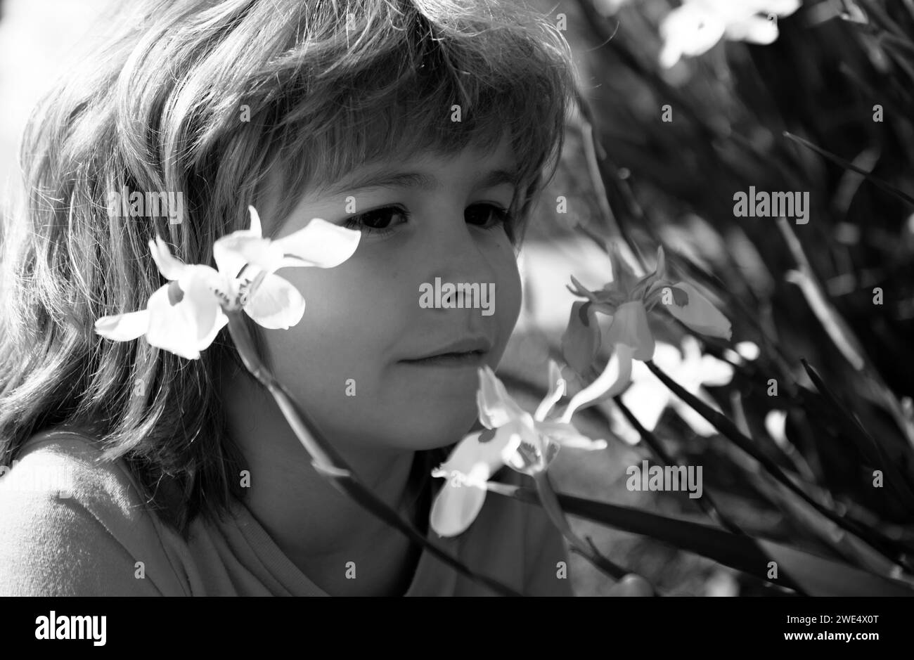 Flower allergy. Spring park. Little boy smelling flowers outdoor. Kid