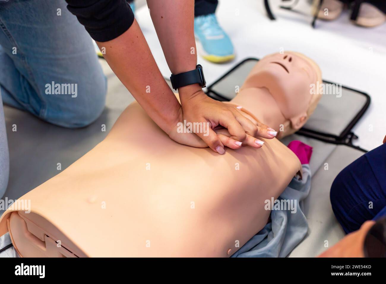 Close-up of hands performing CPR on a training manikin during a first aid class. Stock Photo