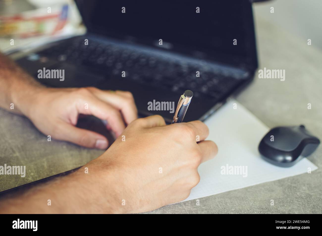 person using laptop, working and taking notes Stock Photo