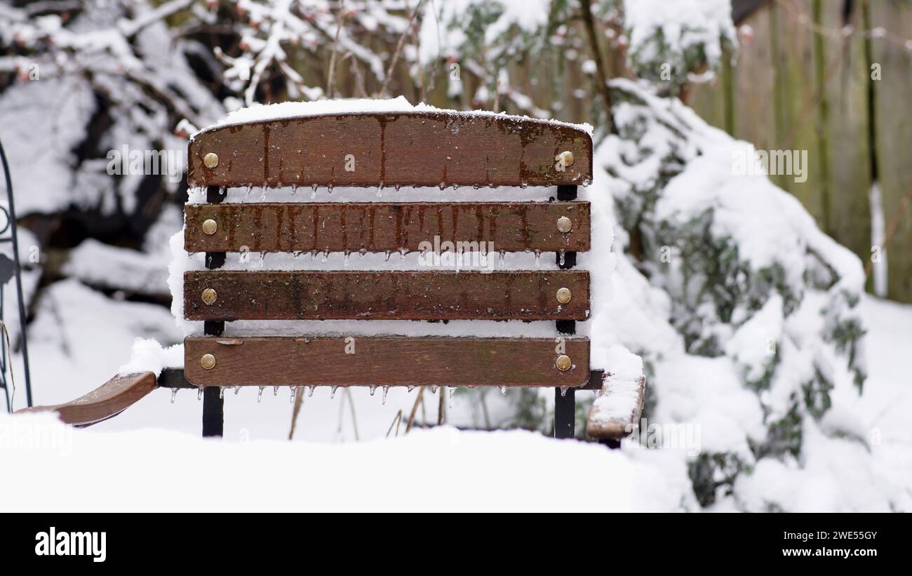 A garden chair covered with ice and snow. Icecubes. Stock Photo