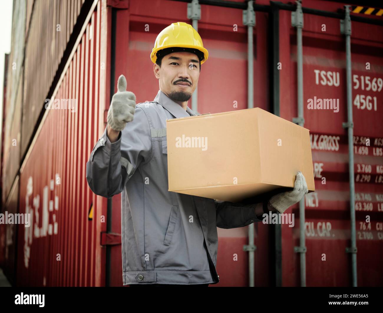 Engineer worker hold cardboard box packaging showing thumbs up on