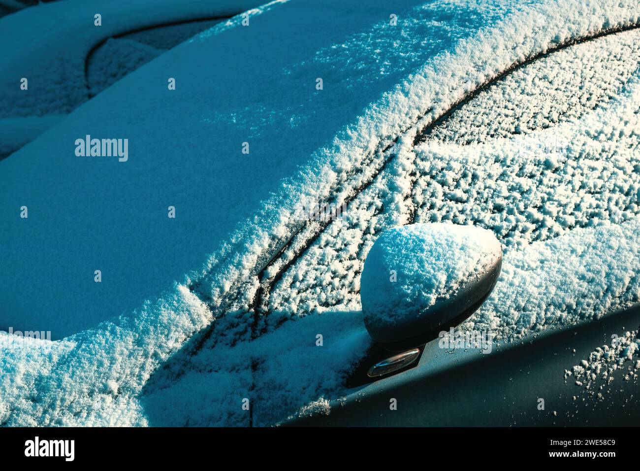 Frozen snow-covered car on parking lot in winter morning, selective focus Stock Photo