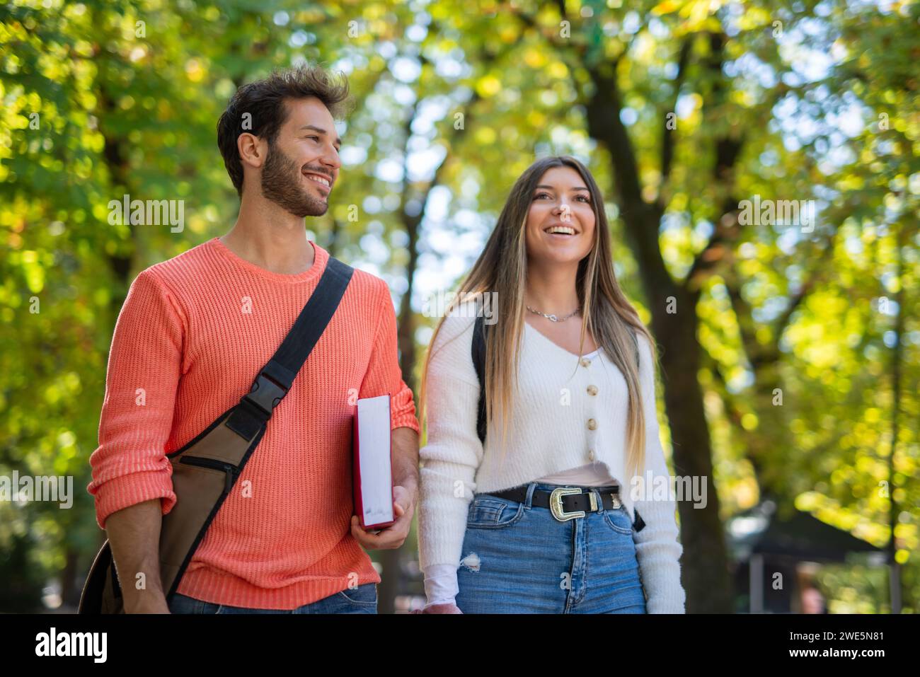 College students walking and talking in a park near their university ...
