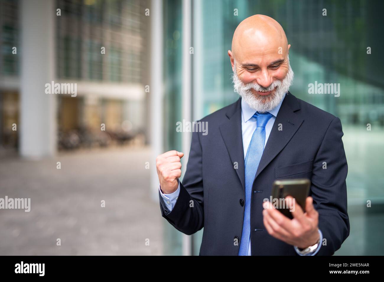 Very happy businessman looking at his phone, good news concept Stock Photo