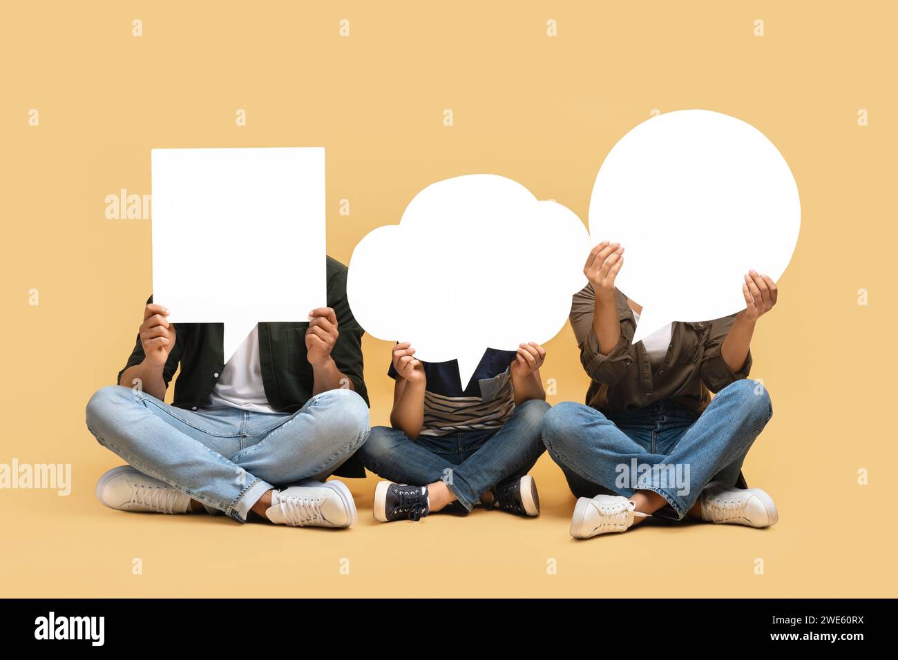 Black mom, dad and son hiding behind empty speech bubbles Stock Photo