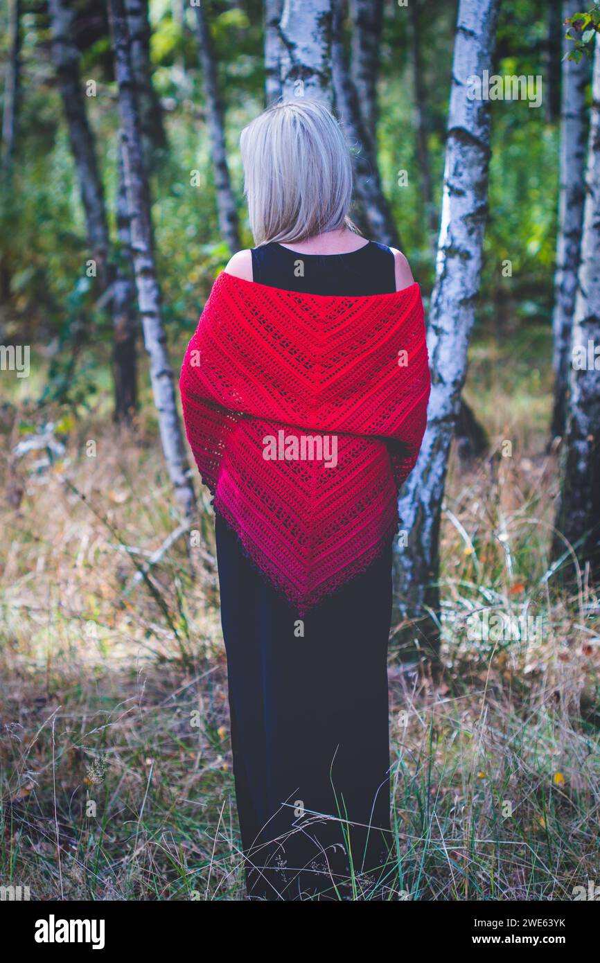 Fourty years old woman show hand crochet made by herself ombre shawl in birch grove Stock Photo