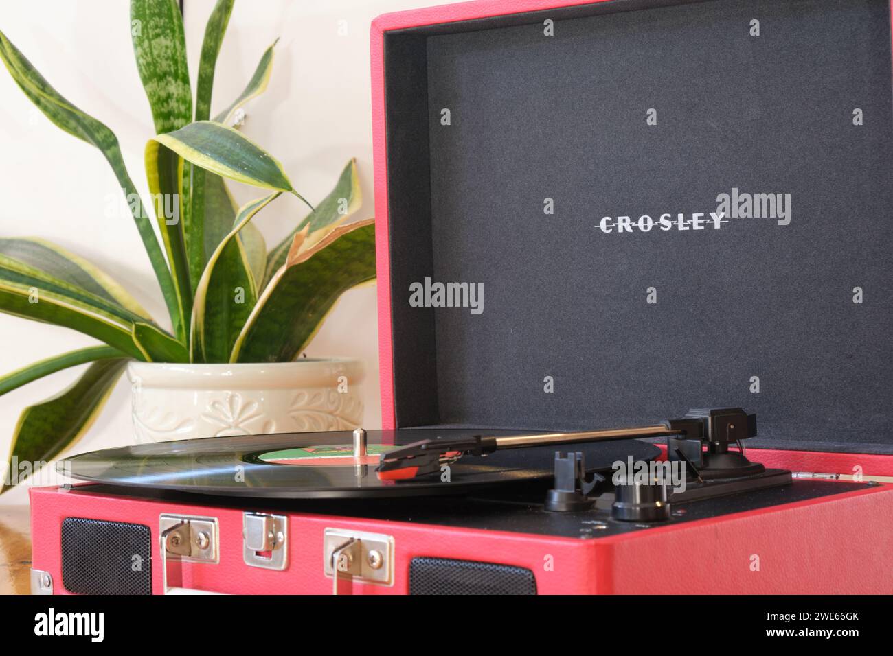 close up retro looking red Crosley recordplayer, with vinyl record on