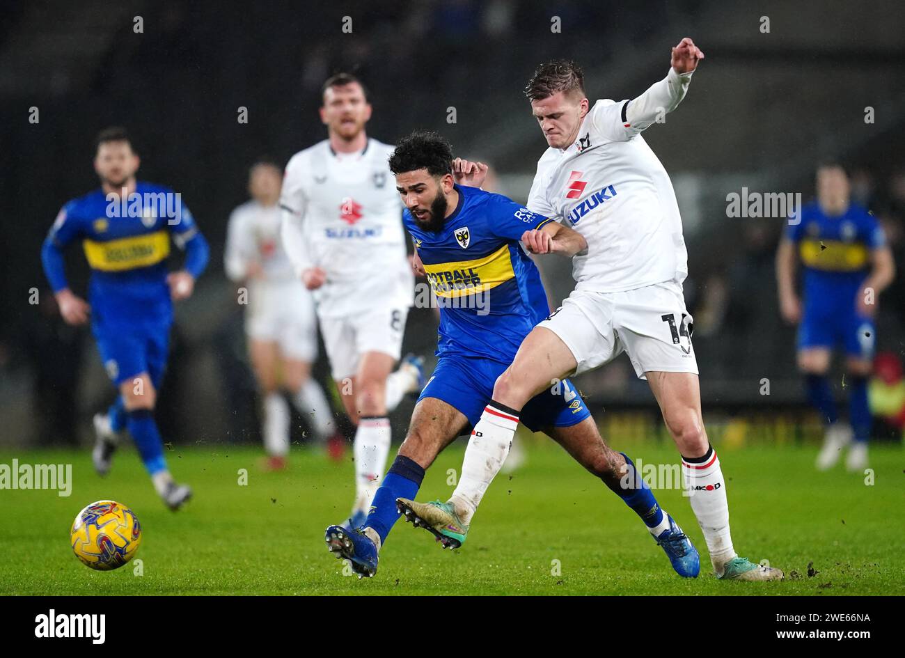 AFC Wimbeldon's Huseyin Biler (left) and Milton Keynes Dons' Joseph Tomlinson battle for the ball during the Sky Bet League Two match at Stadium MK, Milton Keynes. Picture date: Tuesday January 23, 2024. Stock Photo