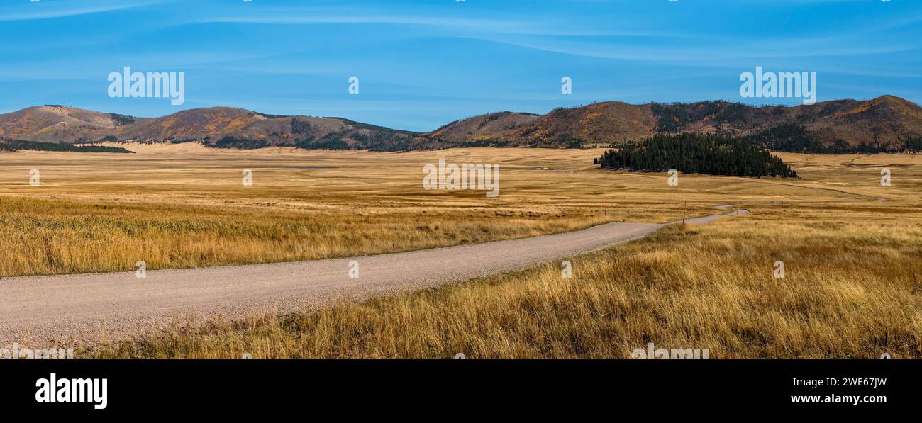 The gravel road from the historic cabin district winds past the Cerro de la Jara lava dome near the Valles Caldera Visitor Center, New Mexico, . Stock Photo