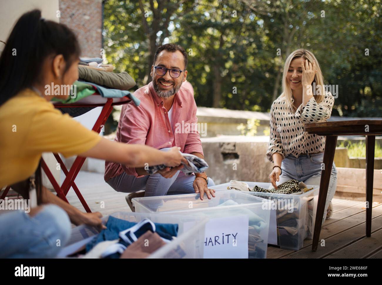 People collecting and sorting clothes for charity Stock Photo