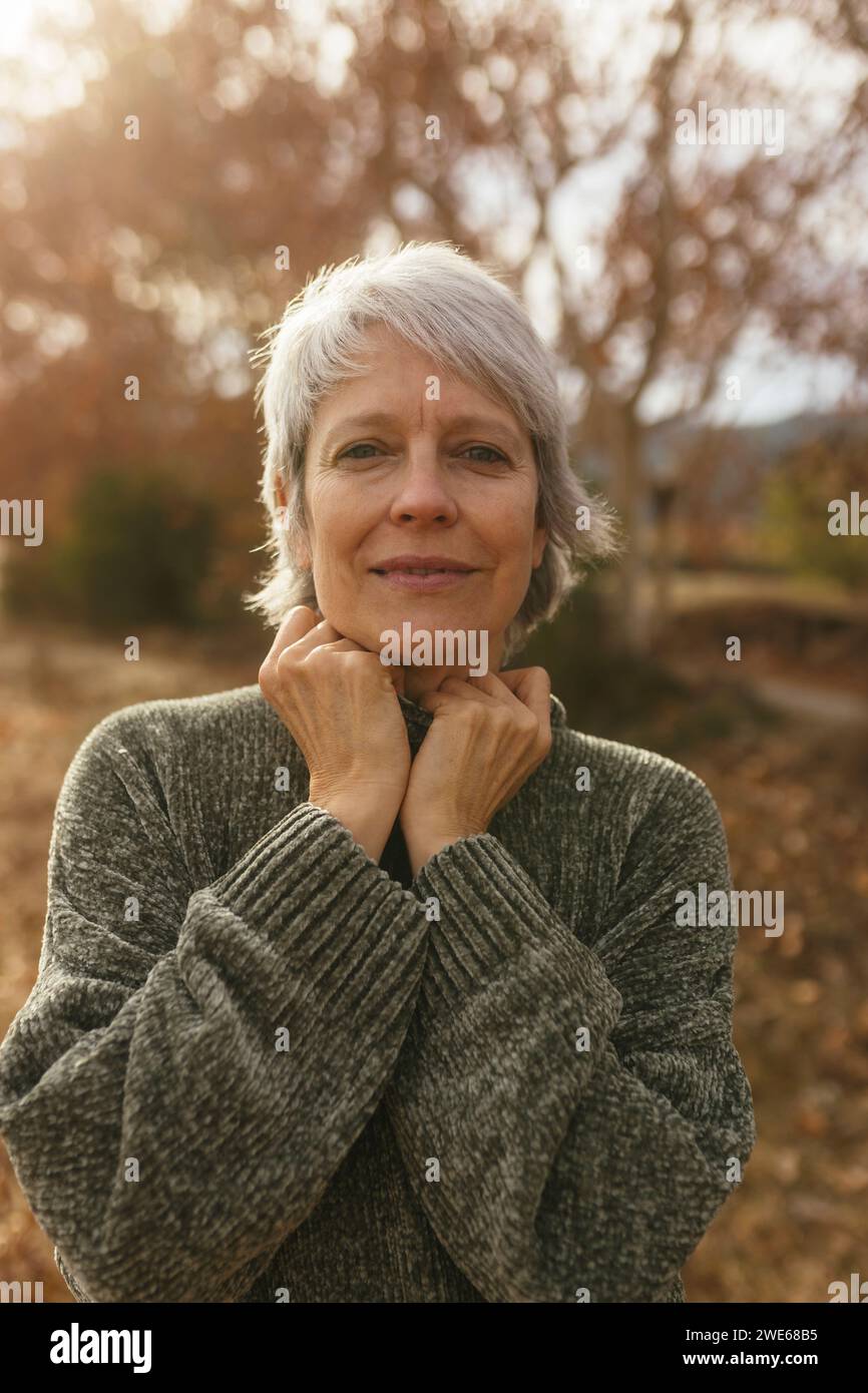 Smiling mature woman with gray hair in nature Stock Photo