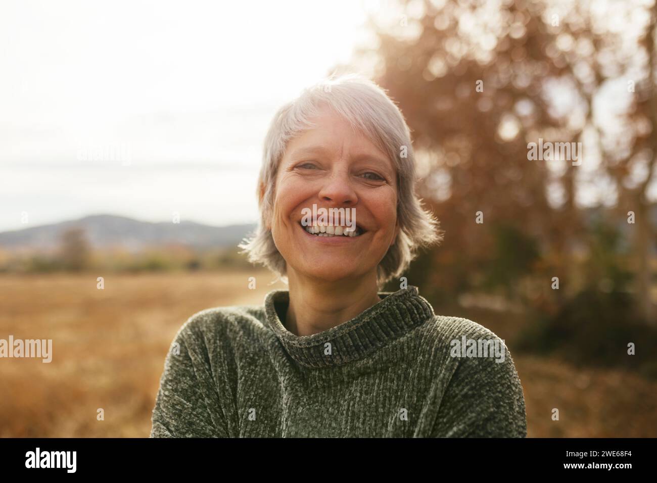 Happy woman with gray hair at field Stock Photo