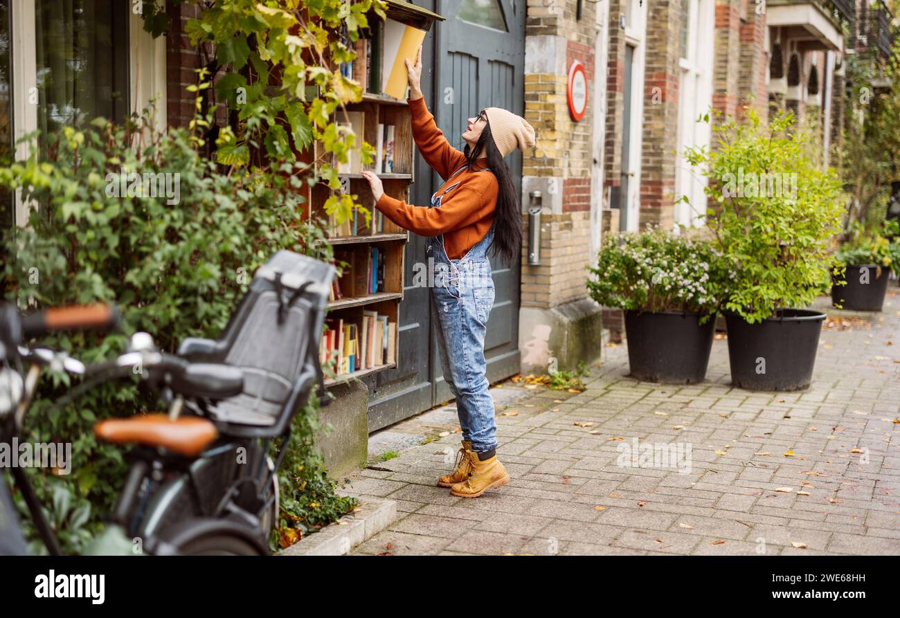 Woman reaching book at bookstore Stock Photo