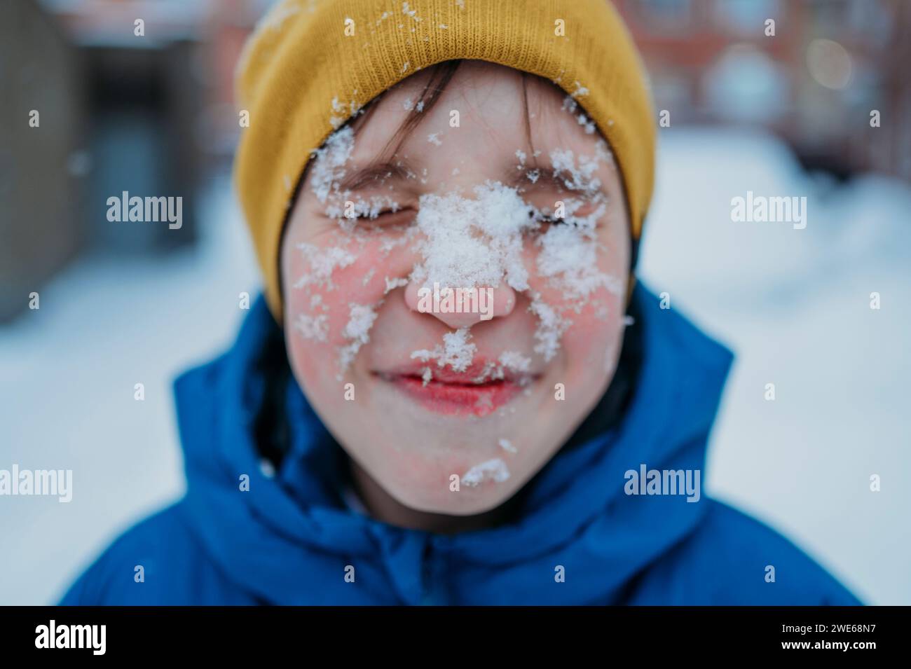 Happy boy with snow on face Stock Photo