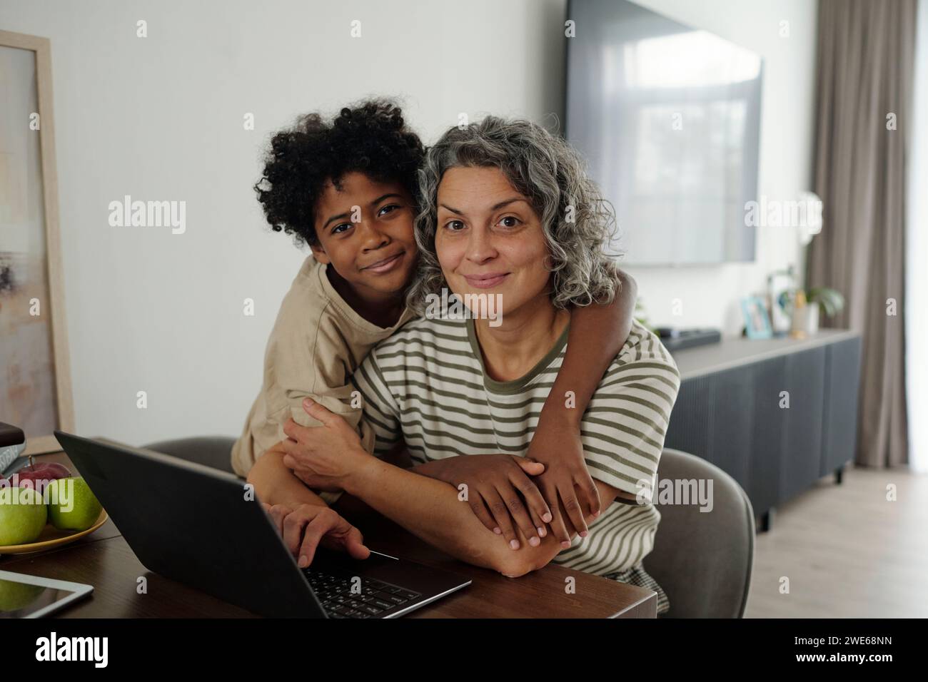 Smiling mother and son hugging each other at home Stock Photo