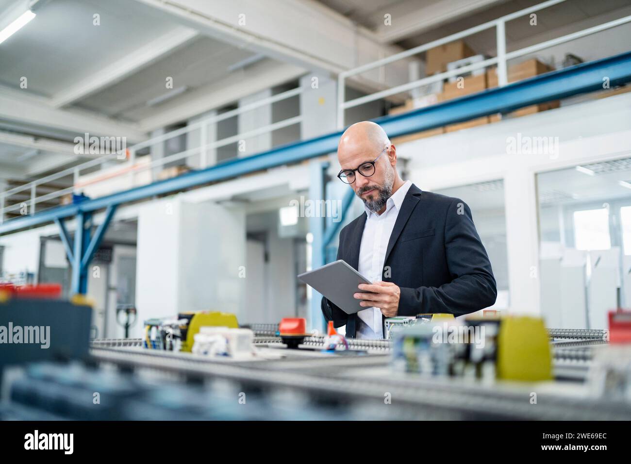 Engineer using tablet PC near machinery in factory Stock Photo