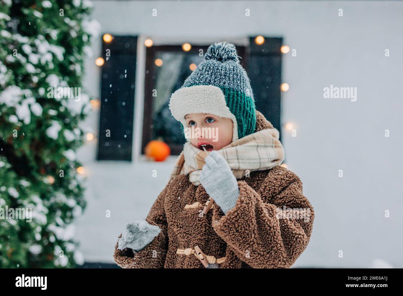 Boy eating icicle on snowy day Stock Photo