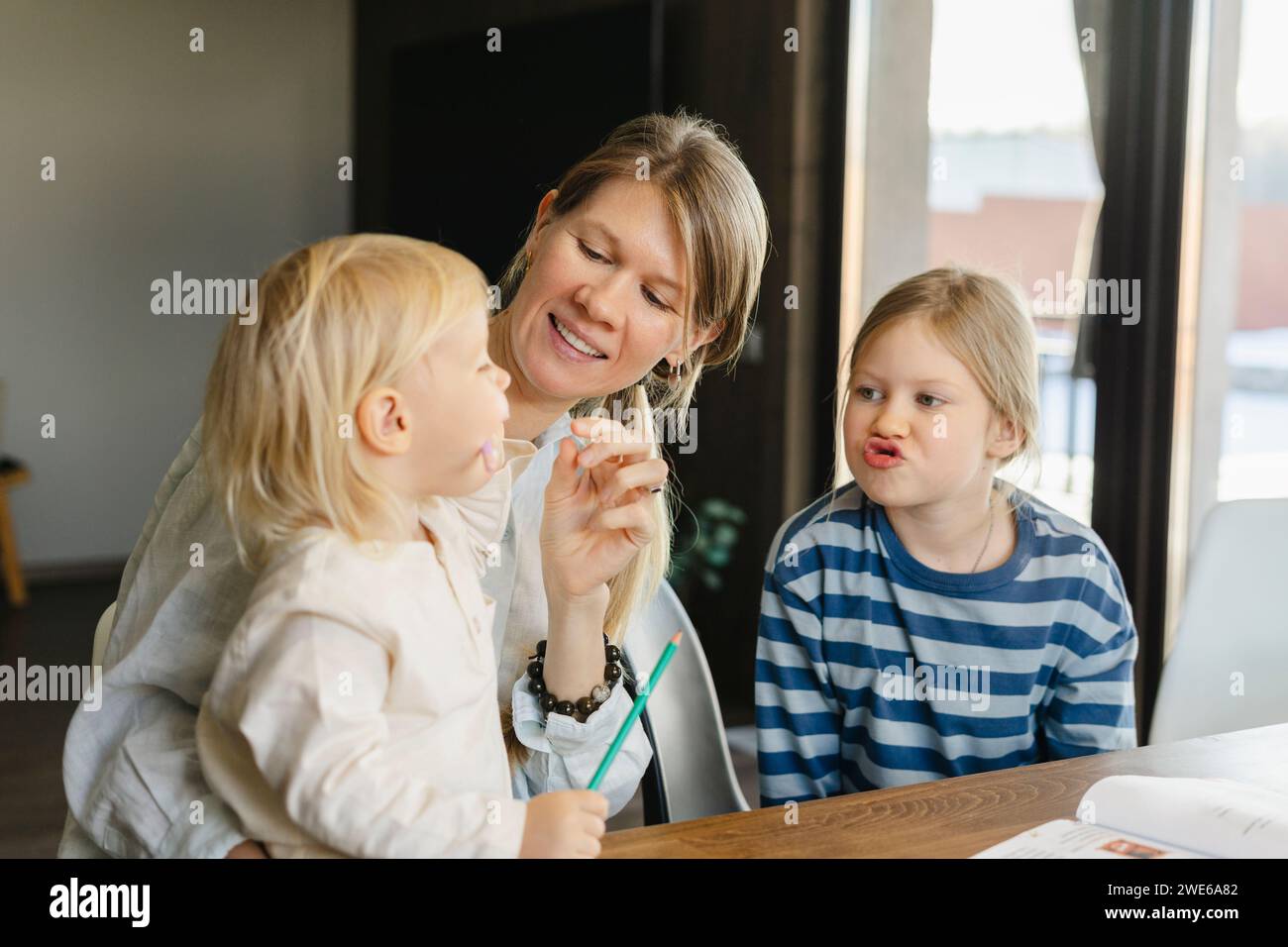 Woman spending leisure time with daughters at home Stock Photo