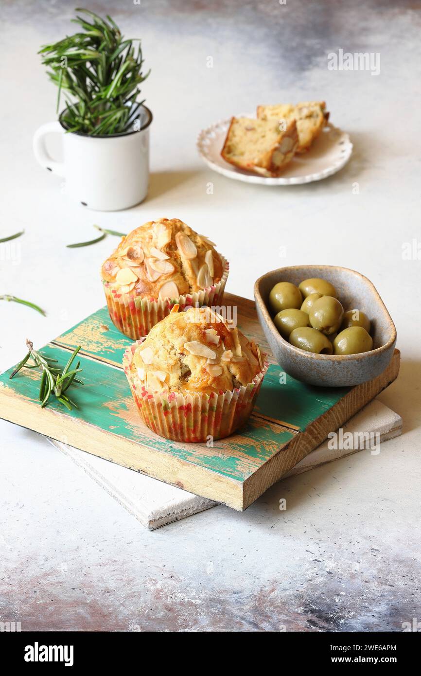Cheese muffins with Emmental cheese and almonds served with green olives Stock Photo