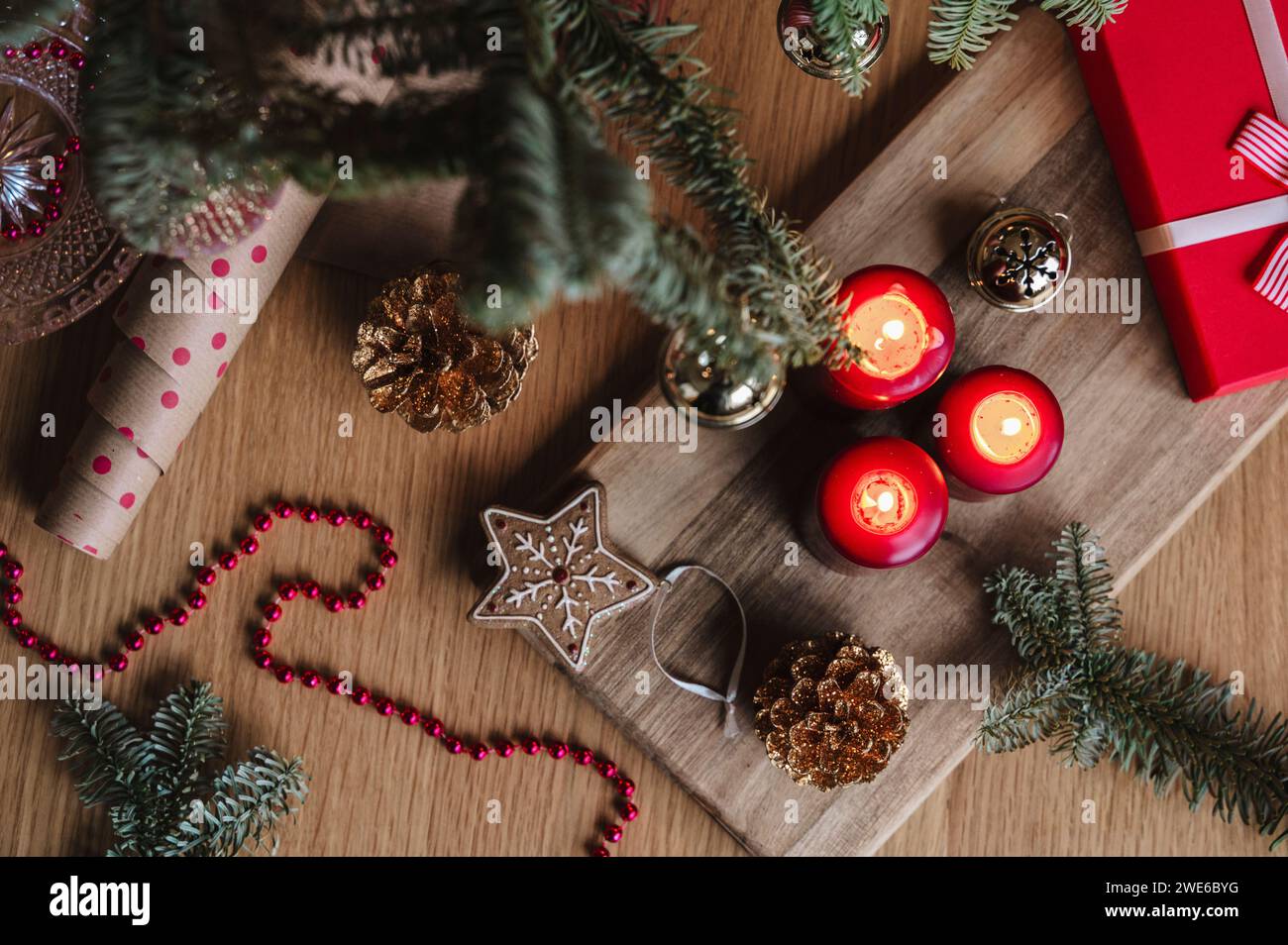 Christmas candles with decoration and gift box on table Stock Photo