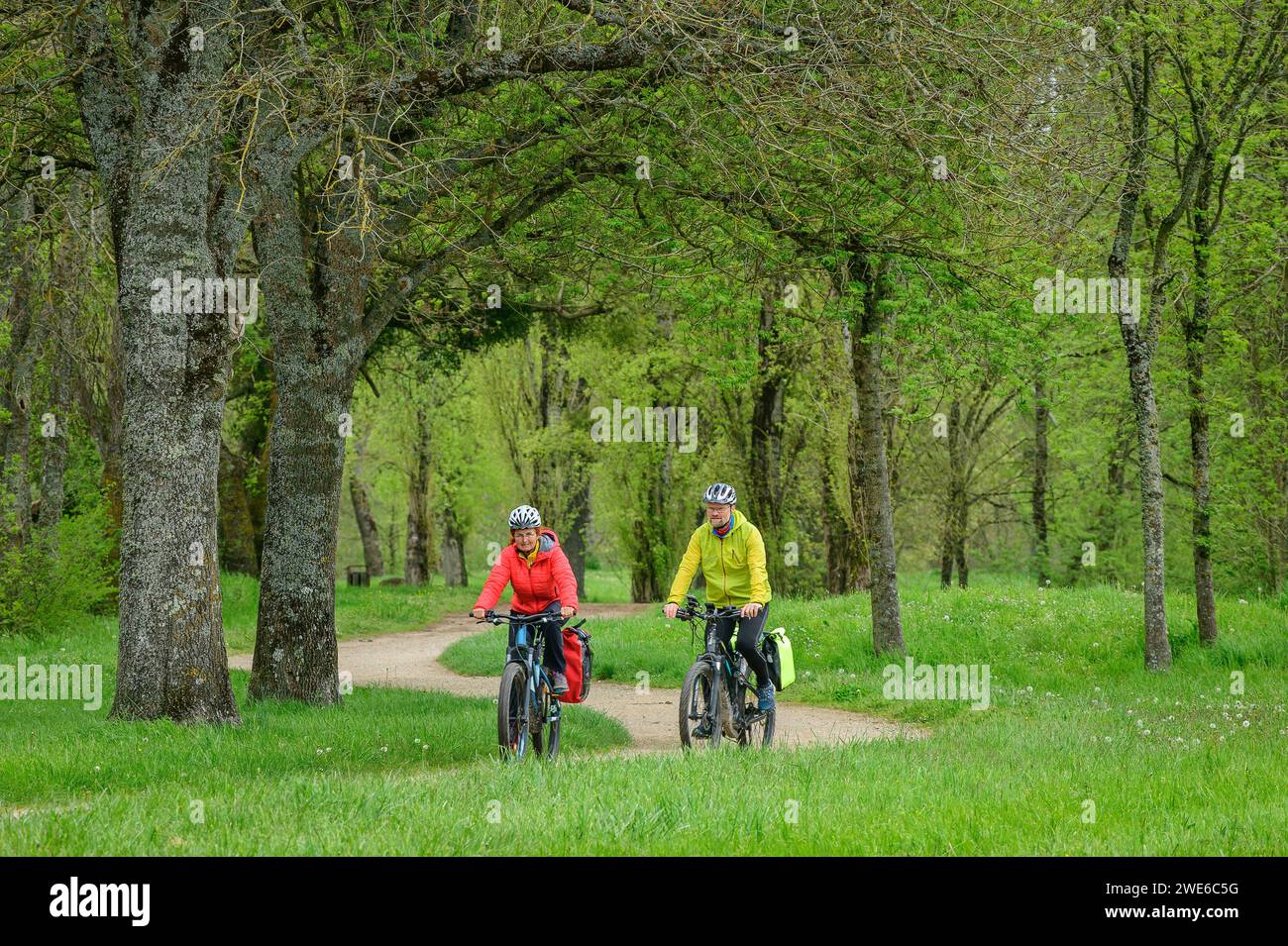 France, CentreVal de Loire, Man and woman cycling through green park