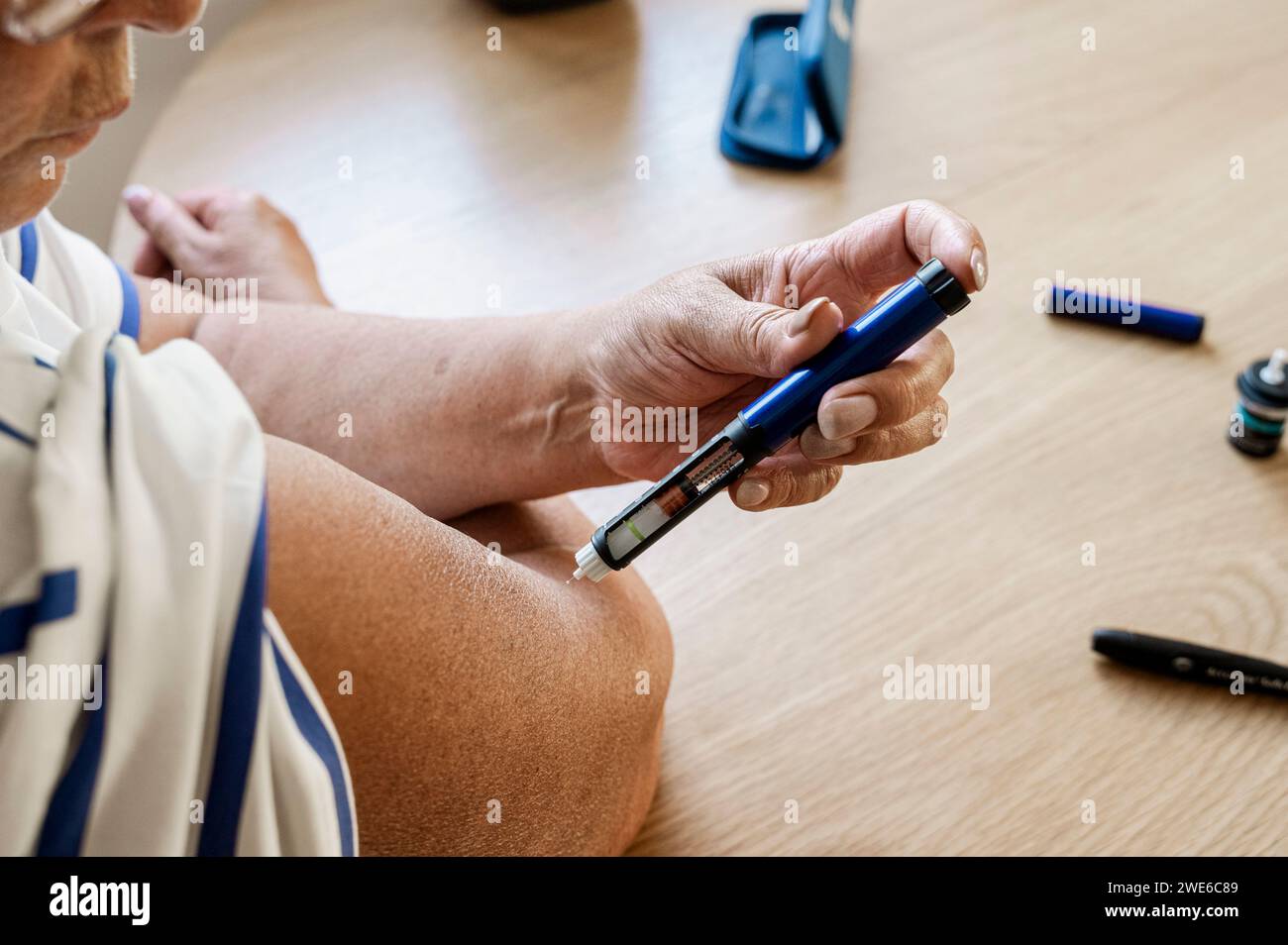 Senior woman injecting insulin at home Stock Photo