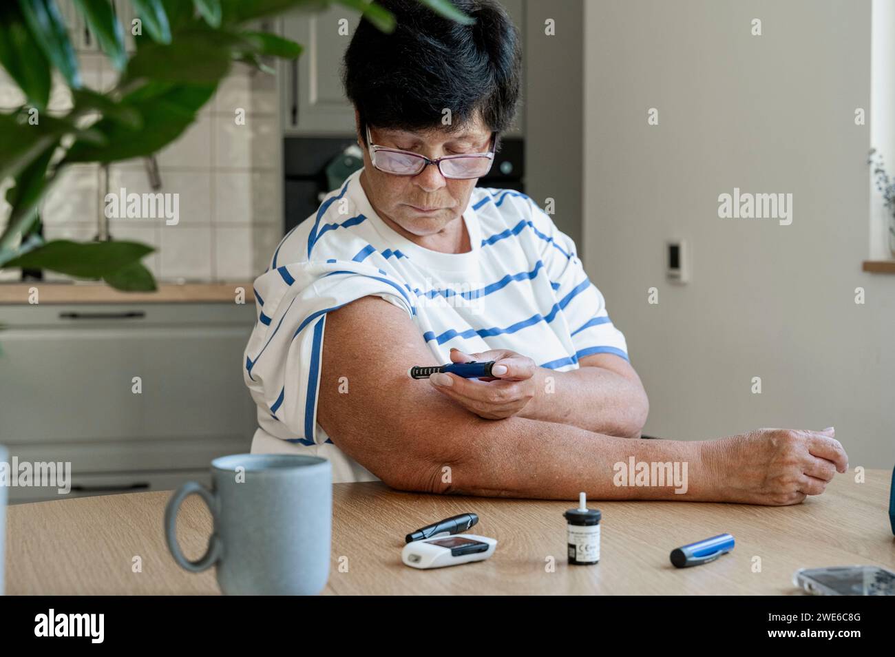 Senior woman injecting insulin with syringe at home Stock Photo