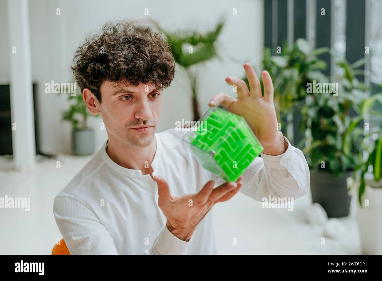 Businessman examining cube maze in office Stock Photo